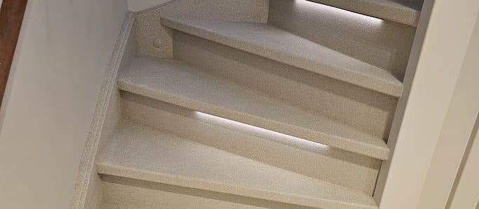 Afgewerkte trap door Creastairs in warm beige Terrazzo-composiet met geïntegreerde LED-verlichting — naadloos, slijtvast, uitgevoerd met het Omnistair EverStep-systeem