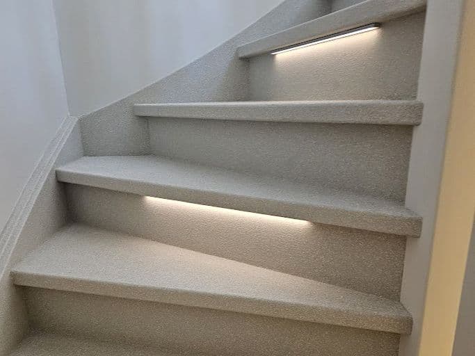 Afgewerkte trap in Terrazzo met geïntegreerde LED-verlichting onder de trapneus — Creastairs uitgevoerd met Omnistair EverStep systeem